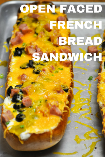 Hot open faced french bread sandwich with green chiles, ham, olives, and cheddar cheese.