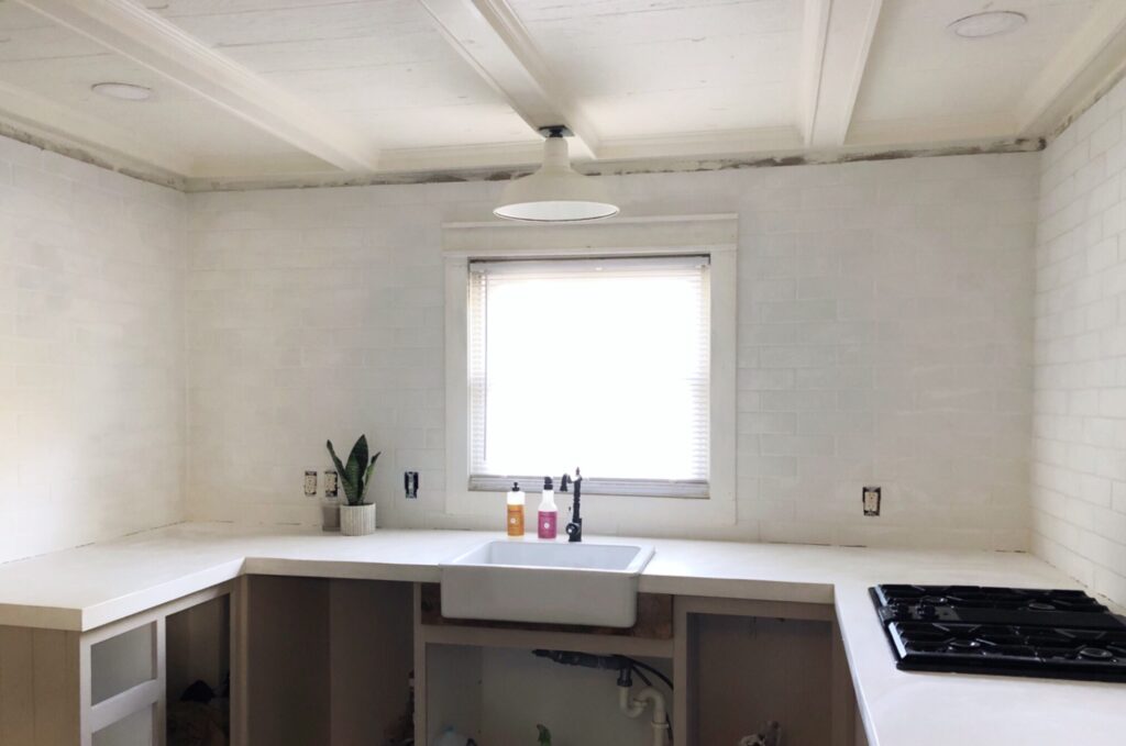 fresh new kitchen with white brick tile and white concrete countertops