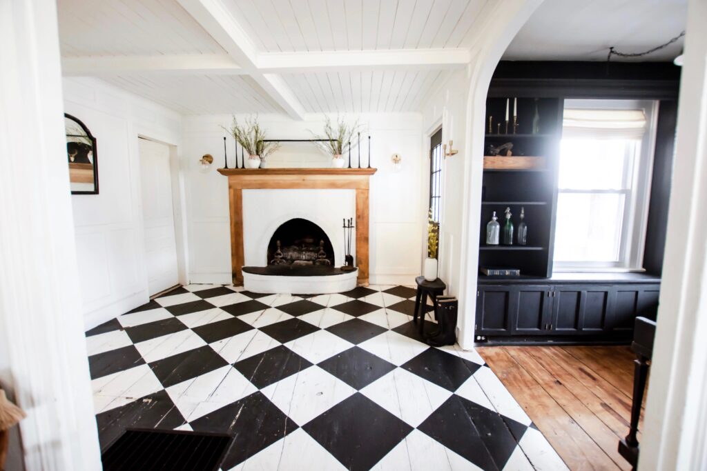 Painted Checkboard Floor on hardwood flooring. Easy flooring udpate. Budget flooring update. Old farmhouse floors. Harlequin flooring. Harlequin floors. Black and white floors.